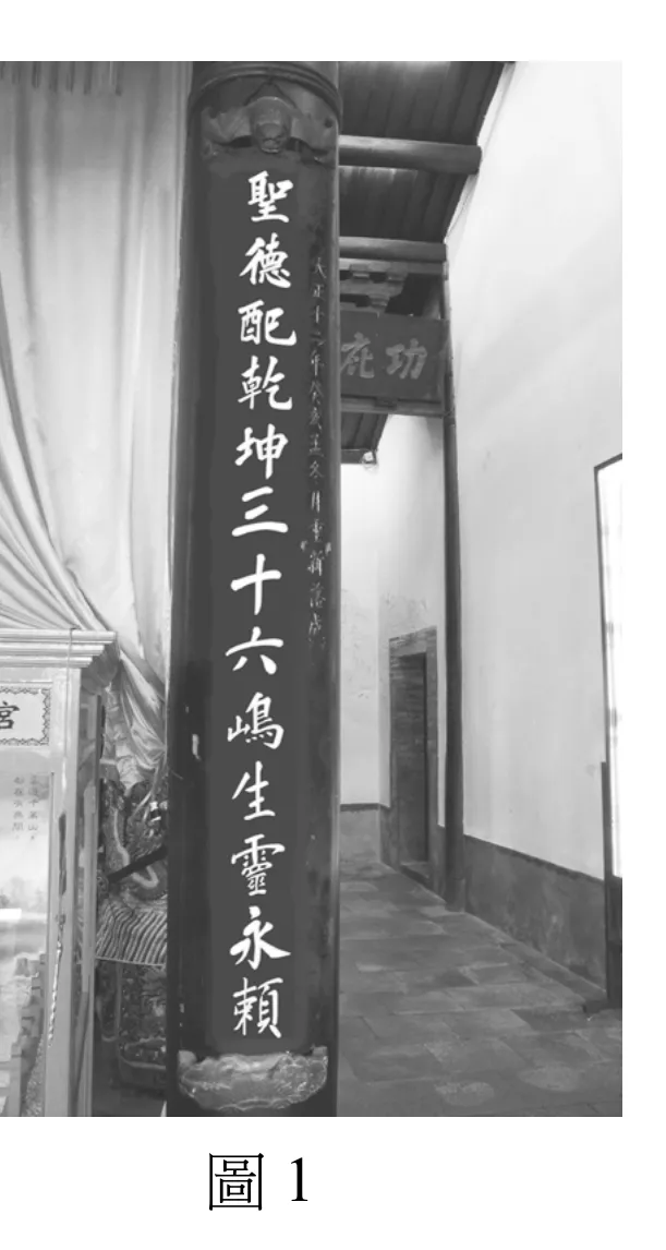 黑白照片，畫面主體為某廟宇的一根圓柱形石柱（廟柱／楹聯柱），柱身黑底貼金字直書對聯上聯「聖德配乾坤　三十六嶋生靈永賴」（嶋通島），柱頭下方另有直書小字年款題記。柱子左側為垂掛的布幔與供桌一角，隱約可見「后宮」匾額字樣；柱子右後方為廟宇木構迴廊，樑架上懸掛直式匾額（右側露出「○功」等字），廊道地面鋪設方磚、牆面素白，走廊向內延伸至盡頭的門洞。圖下方置中標示「圖1」。