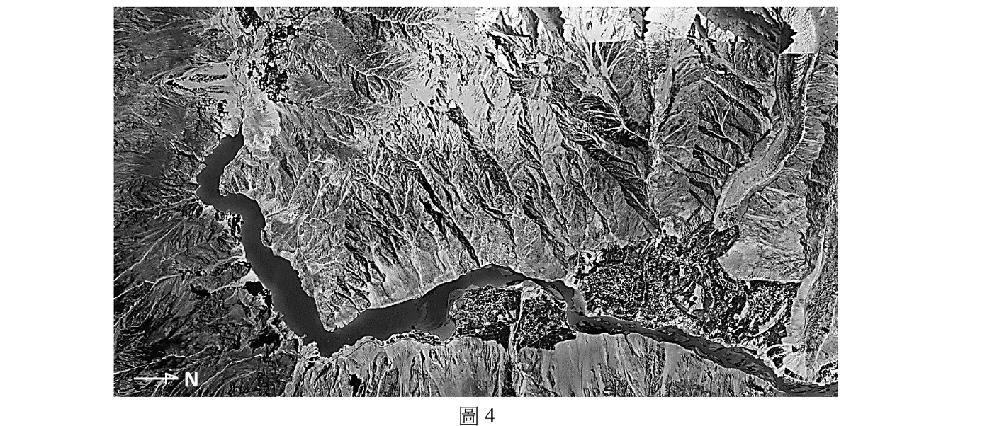 圖4為灰階空拍／衛星影像。畫面左下角有一枚指北符號，箭頭水平指向畫面右方，箭頭旁標示字母「N」，代表本圖北方對應畫面「右側」（本圖並非上方為北的常規地圖，而是整體順時鐘轉了90°：畫面右＝北、畫面下＝東、畫面左＝南、畫面上＝西）。畫面中央偏左有一條深色狹長水體（堰塞湖），其上端（畫面偏上方）與一片淺灰色、由上往下呈扇形展開的地貌相接——該扇形地貌質地與周圍山坡不同、由一個尖點向下展開變寬，判斷應為造成堵塞的大規模土石滑落堆積扇；水體自扇形堆積下緣向下、向右延伸成一片較寬闊的湖面，再沿畫面下方轉為狹窄水道，向右延伸出畫面右緣。